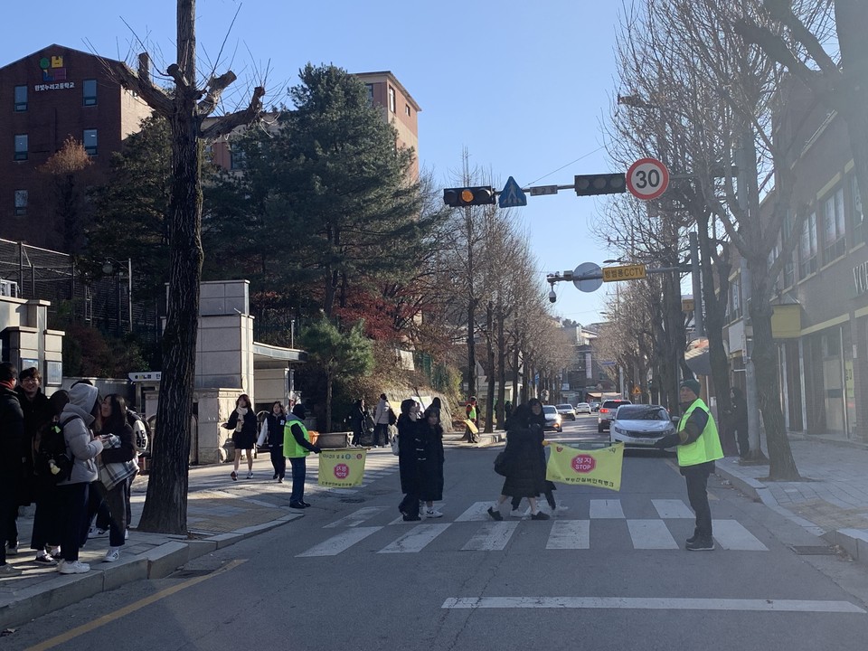 6일 오후 2시40분께 동두천시 한빛누리고등학교 앞 횡단보도에서 하교하는 학생들의 안전을 위해 실버인력 교통뱅크 어르신들이 차량 정지 깃발을 이용 교통정리를 하고 있다. (사진=오기춘 기자)