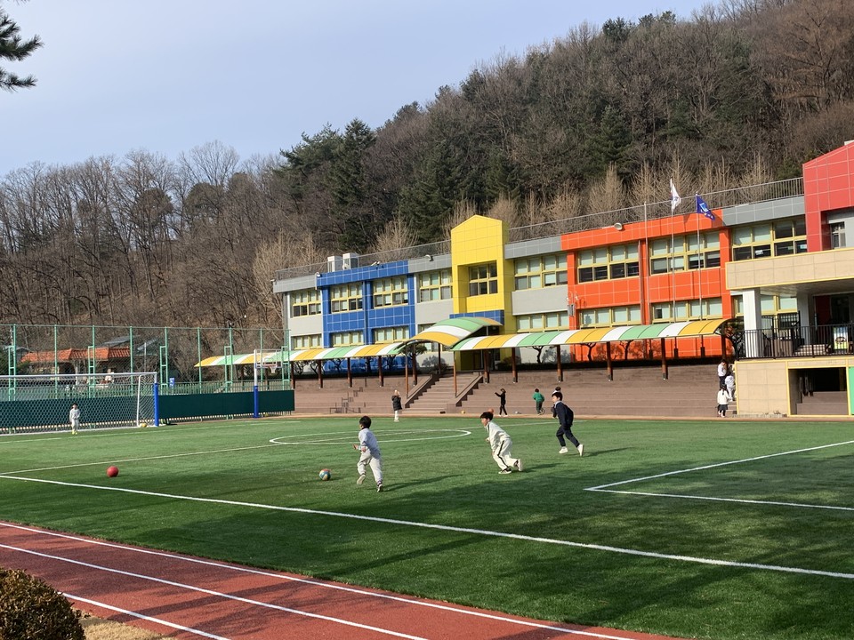 13일 낮 12시40분께 동두천시 탑동동에 소재한 탑동초등학교 어린이들이 체육시간을 맞아 인조 잔디가 깔려 있는 운동장에서 공을 차며, 즐거운 시간을 보내고 있어 미소 짓게 만들고 있다. (사진=오기춘 기자)