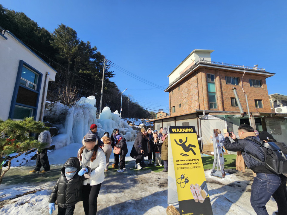 11일 오후 1시12분께 가평 어비계곡을 찾은 외국인들이 빙벽으로 가기 전 꽁꽁 언 얼음이 신기한 듯 얼음으로 만들어진 조형물을 배경으로 기념사진을 남기고 있다. (사진=이건구 기자)
