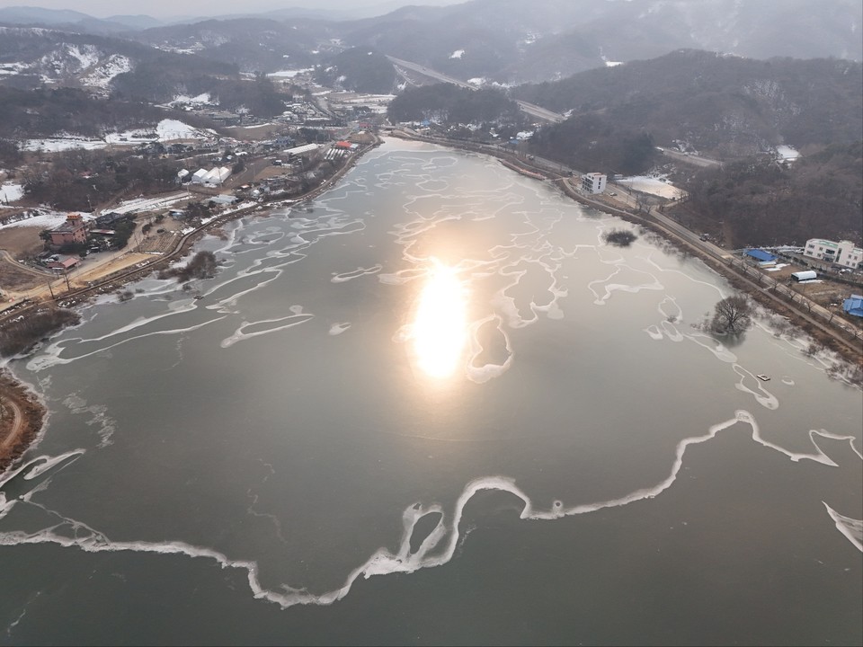 13일 오후 2시31분께 안성시 죽산면 용설리에 위치한 꽁꽁 언 용설저수지가 커다란 황금빛 태양을 머금고 있다. (사진=김종대 기자)