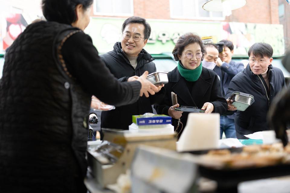 26일 오후 의왕도깨비시장을 방문한 김동연 경기도지사와 정우영 배우자가 구매한 전을 다회용기에 포장하고 있다. (사진제공=경기도)