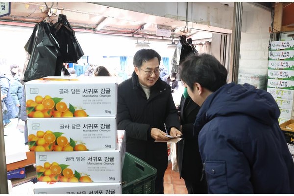 사진은 지난달 26일 김동연 경기도지사와 정우영 배우자가 설맞이 의왕도깨비시장 방문하여 과일 등을 구매하고 있다. (사진제공=경기도)
