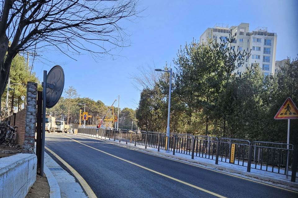 3월 개교하는 모담초·중학교 등하굣길에 대한 안전 통학을 우려하는 목소리가 나오는 가운데 보행로가 한쪽뿐인, 양방향 내리막길 도로. (사진=권용국 기자)