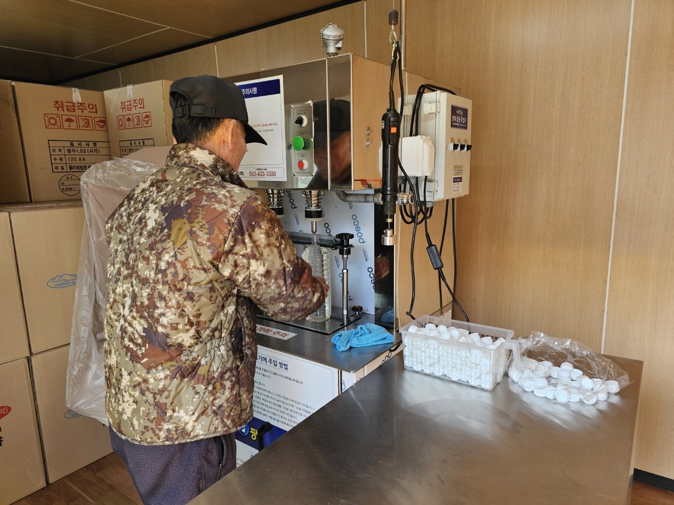 채집된 고로쇠 수액을 2L물병에 담아 상품을 만들고 있는 소리산작목반원. (사진=이건구 기자)