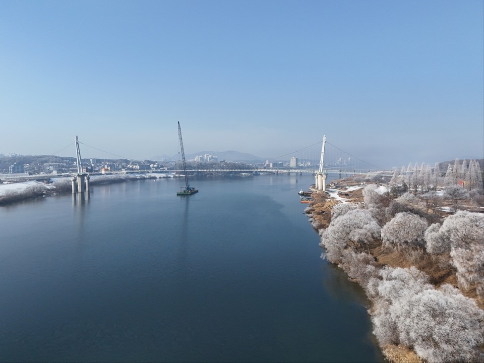 절기상 입춘을 하루 앞둔 2일 오전 11시12분께 여주시 남한강변 천년고찰 신륵사 인근에 짙게 낀 안개가 사라진 자리에 상고대가 활짝 피어 있다. 올해 상반기 준공을 앞둔 여주 출렁다리가 보인다. (사진=김광섭 기자)