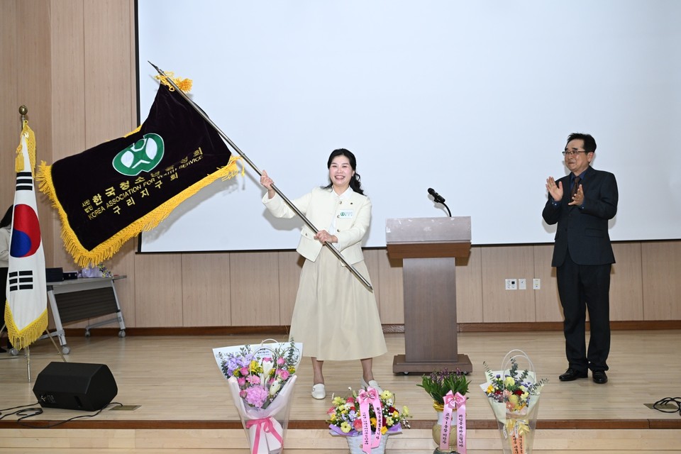 (사)한국청소년육성회 구리지구회 제2대 회장에 취임한 황의순 신임 회장이 지구회기를 이양 받아 힘차게 흔들고 있다. (사진제공=한국청소년육성회 구리지구회)