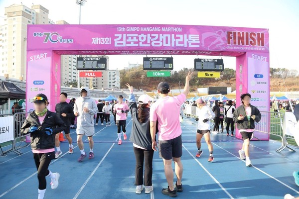 지난 13일 진행된 ‘제13회 김포한강 마라톤대회’에서 김포지부 봉사자들이 마라토너를 위해 응원하고 있다. (사진 제공 = 신천지자원봉사단 김포지부)