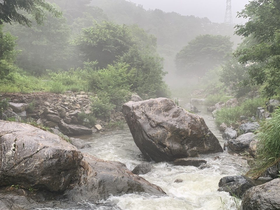 28일 오후 5시5분께 동두천 왕방계곡에 비가 내리면서 만들어진 물안개 사이로, 웅장한 모습을 띤 ‘웅인세소(雄認世所)’의 바위가 주변을 압도하고 있다. (사진=오기춘 기자)