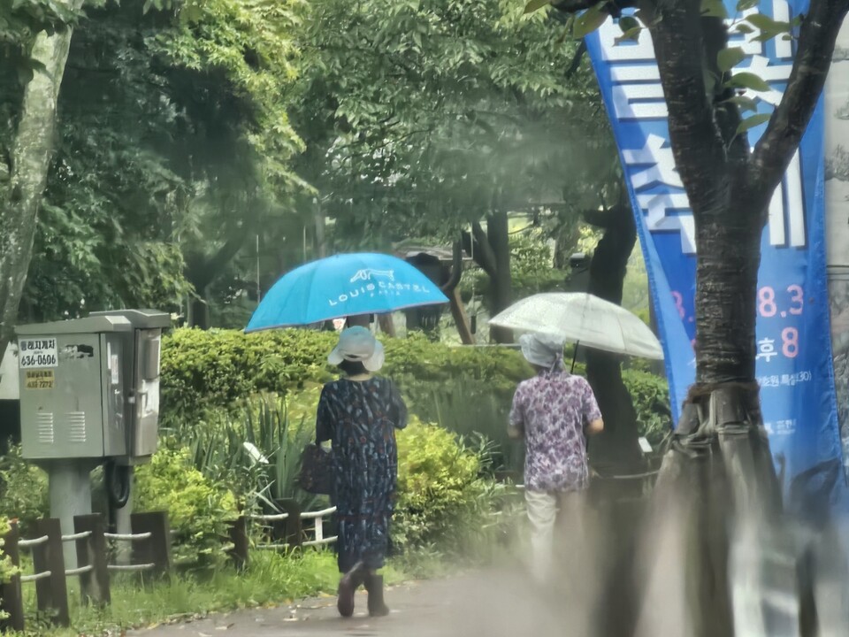 16일 오후 3시15분께 이천 설봉호수에는 굵은 장대비가 쏟아지고 있는 가운데 시민들이 우산에 쓰고 산책을 즐기고 있다. (사진=송석원 기자)