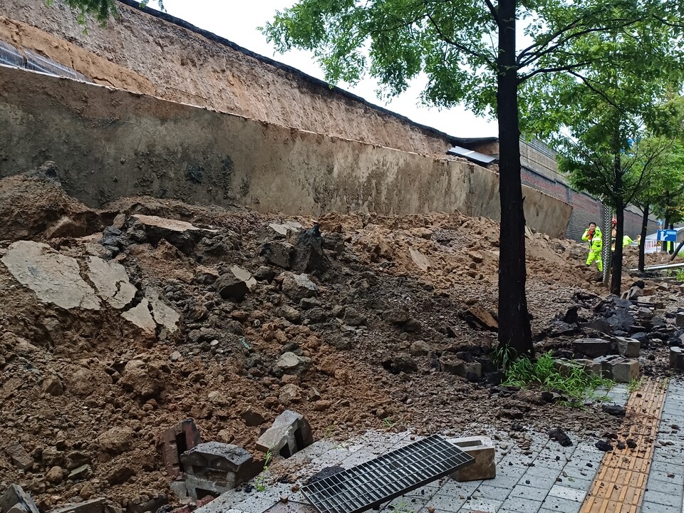 16일 오후 7시4분께 오산시 가장동 가장교차로 인근에서 약 10ｍ 높이의 옹벽이 도로 쪽으로 무너지며 차량 2대를 덮쳐 구조작업을 벌이고 있다. (사진제공=경기도소방재난본부)