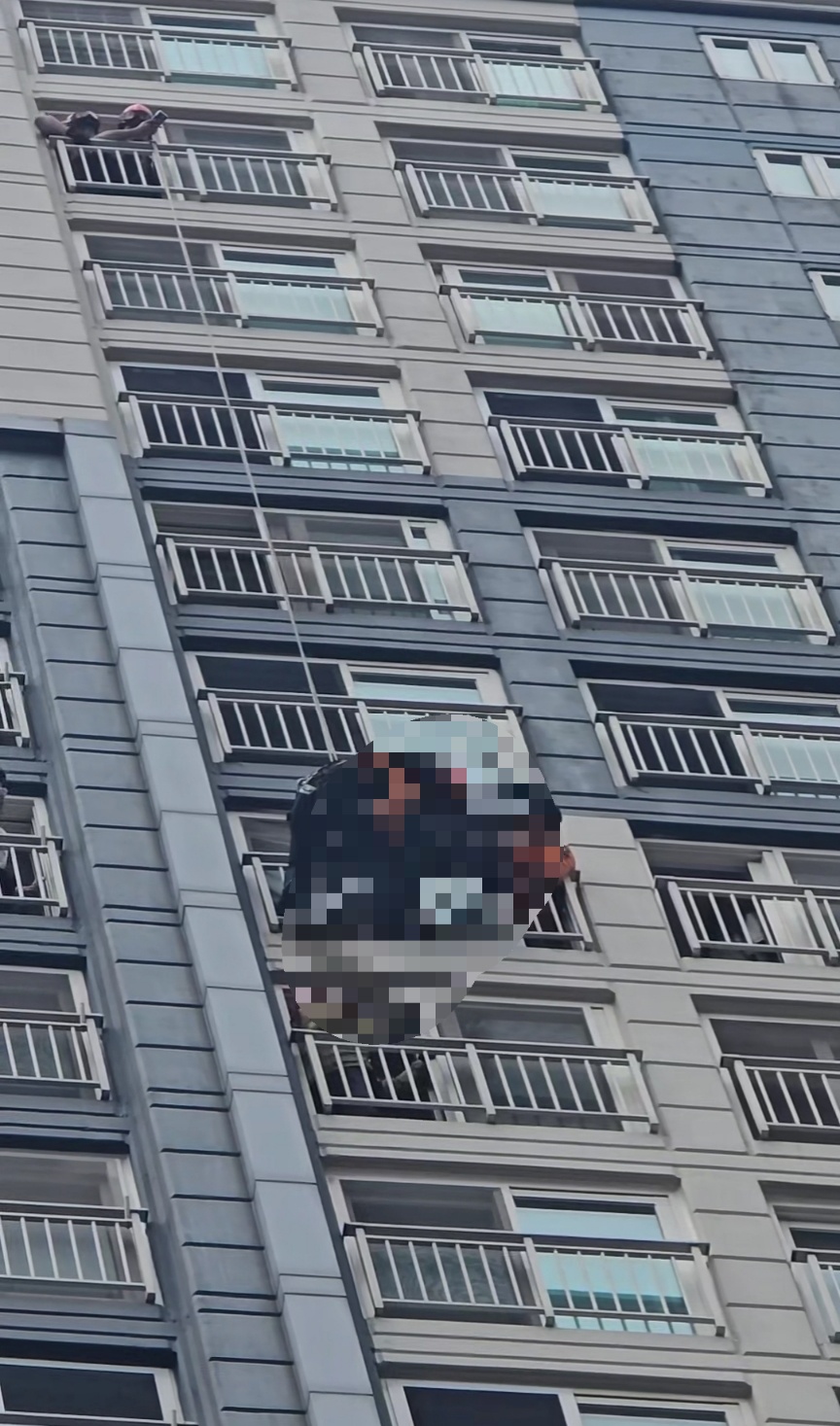  수원시의 한 아파트 고층부에서 여성이 난간에 거꾸로 매달리는 아찔한 사고가 발생했다. 소방당국이 출동해 약 30분 만에 구조에 성공했다. (사진제공=경기도 소방재난본부)