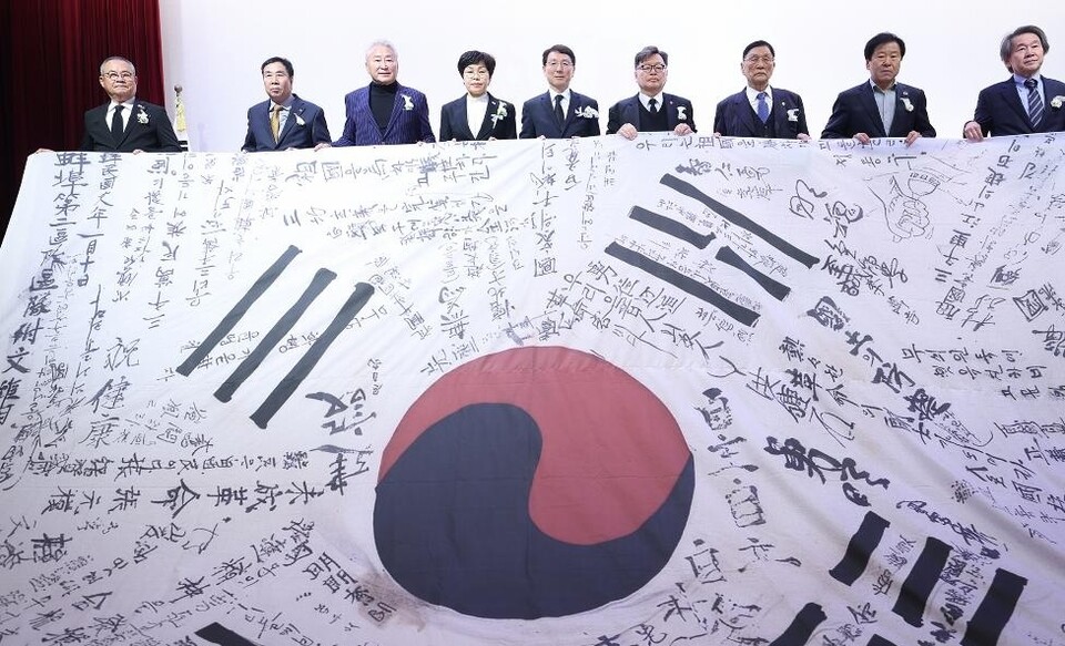 17일 오전 수원 보훈교육연구원 대강당에서 열린 제86회 순국선열의 날 기념식에서 김성중 행정1부지사 등 참석자들은 독립운동가들의 서명이 새겨진 태극기를 펼쳐 들고 순국선열의 희생을 기렸다. (사진제공=경기도)