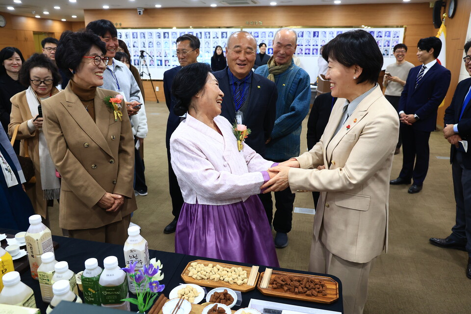 송미령 농림축산식품부 장관이 8일 정부세종청사에서 열린 ‘2025년 대한민국식품명인 지정서 수여식’에서 경기 이천의 도라지정과 명인 박일례씨와 손을 맞잡고 축하 인사를 나누고 있다. (사진제공=농식품부)