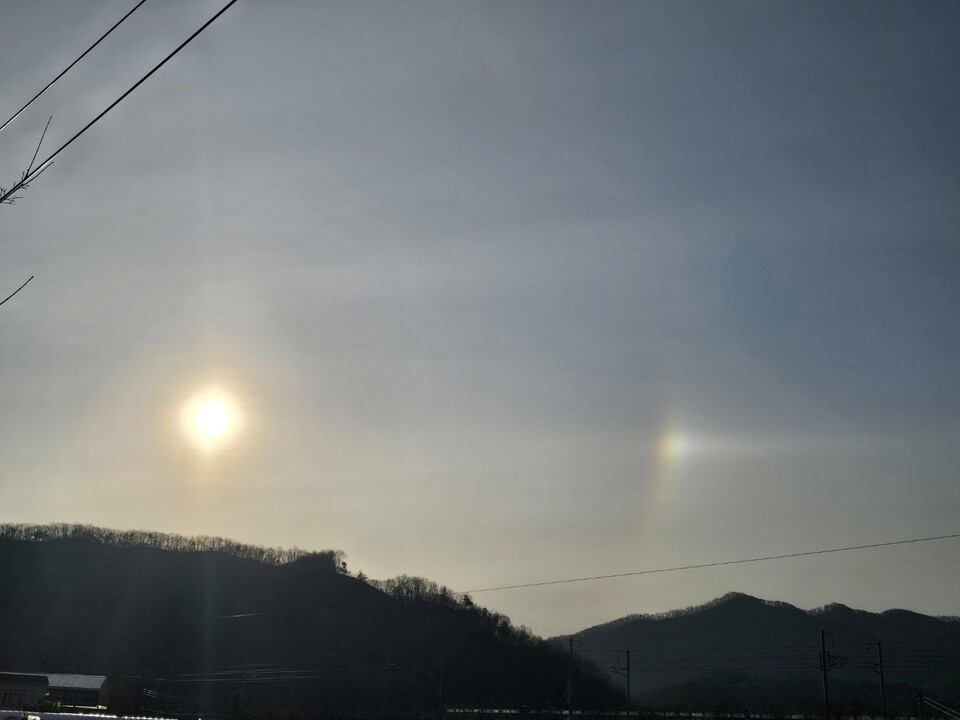 새해 첫날인 1월1일 오전 9시33분께 광주시 곤지암읍 광여로에서 바라본 맑은 하늘에 떠오른 해의 오른쪽으로 무지갯빛이 번지며 ‘환일(幻日)’ 현상이 관측되고 있다. (사진=김광섭 기자)
