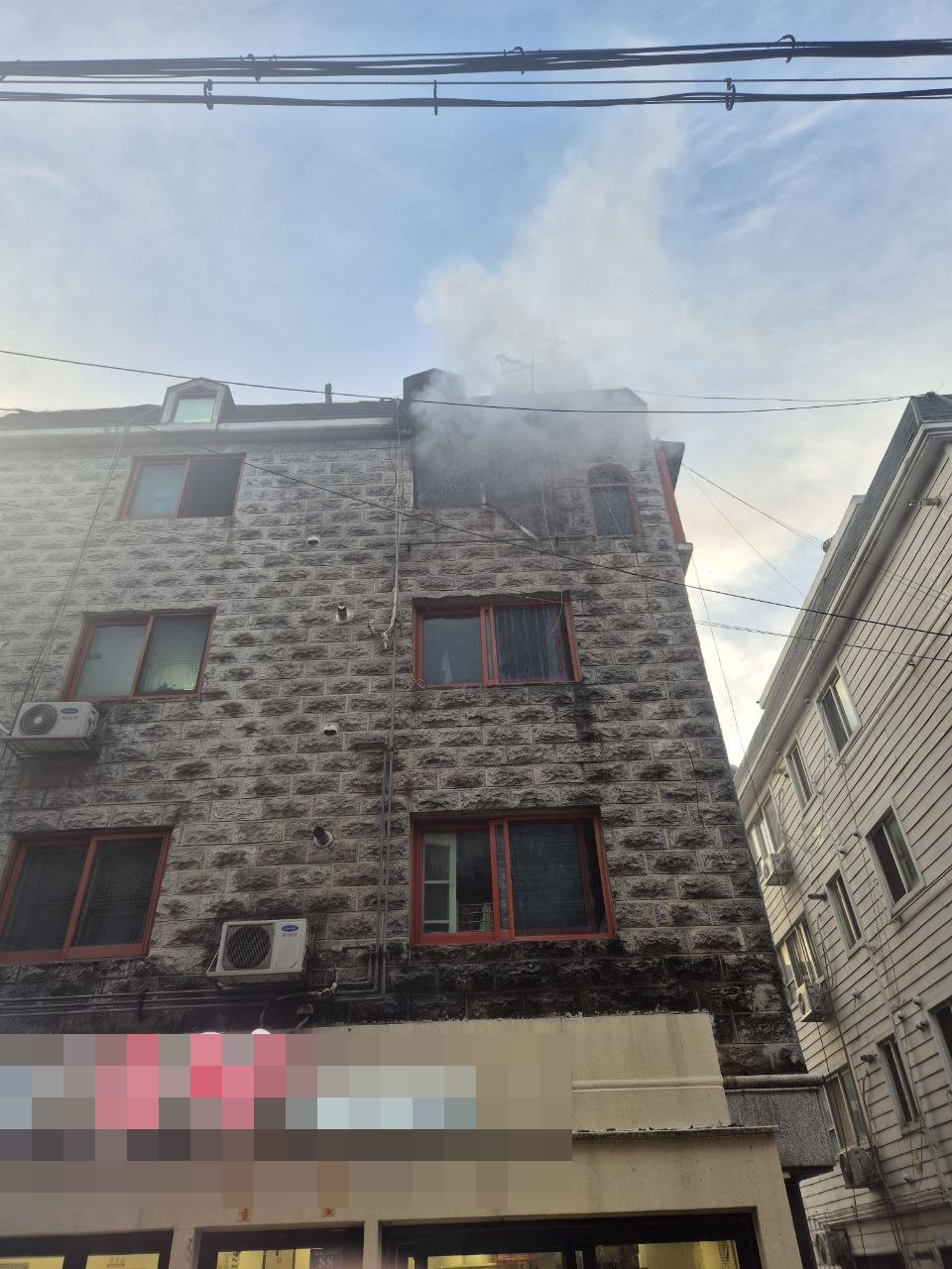 12일 오후 시흥시 정왕동 한 빌라에서 화재가 발생해 상층부 창문 주변으로 연기가 치솟고 있다. (사진제공=경기도소방재난본부)