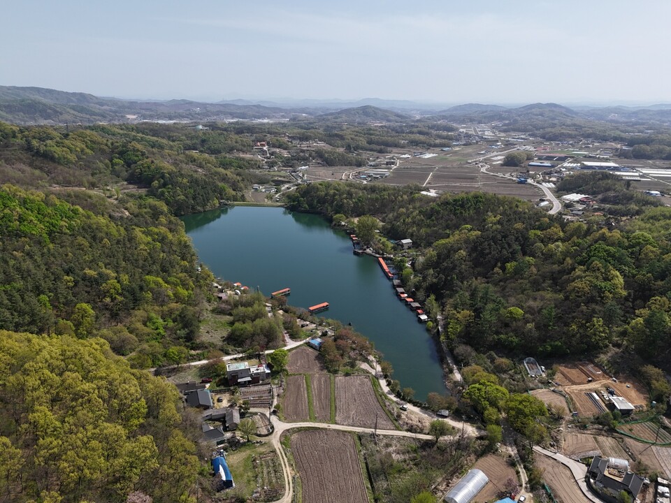 18일 오후 2시36분께 저수지 주변 산림이 연둣빛으로 변하며 계절의 변화를 보여주고 있다.