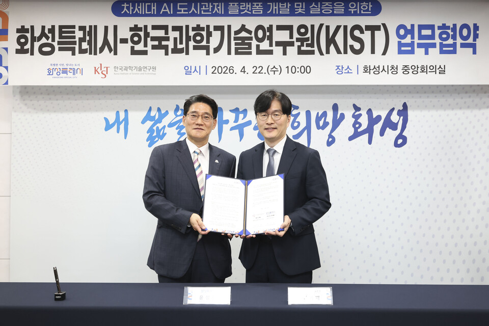 윤성진 화성특례시 제1부시장(왼쪽)과 김익재 한국과학기술연구원 AI 로봇 연구소 소장이 AI 도시관제 플랫폼 개발 업무협약을 체결하고 기념촬영을 하고 있다. (사진제공=화성시)