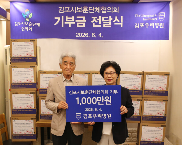 김포우리병원 김지일 행정원장이 임종철 김포시보훈단체협의회장에게 기부금을 전달하고 기념사진을 촬영하고 있다. (사진제공=김포우리병원)