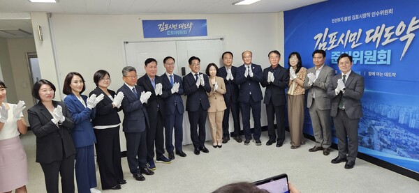 이기형(가운데) 김포시장 당선인과 채신덕(이 당선인 왼쪽) 인수위원장을 비롯한 인수위원들이 이달 11일 인수위인 '김포시민 대도약 준비위원회'의 현판식을 갖고 화이팅을 외치고 있다. 사진=권용국 기자