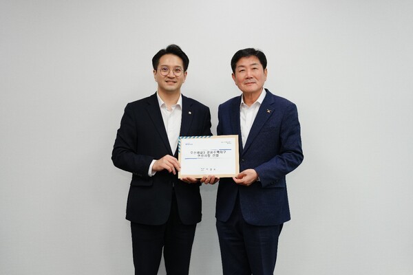 조용호 오산시장(오른쪽)이 전용기 의원에게 건의서를 전달하며 기념촬영을 하고 있다. /사진제공=오산시