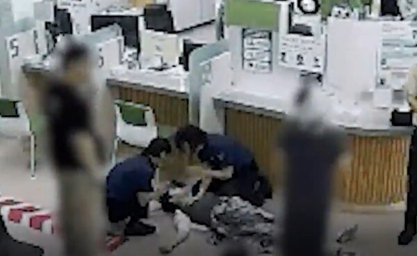 경찰관이 갑자기 쓰러진 50대 여성에게 심폐소생술을 하고 있는 장면. /연합뉴스