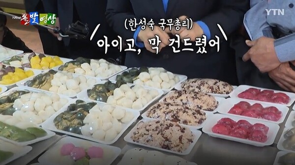 한성숙 국무총리가 지난 17일 서울시 관악구 신원시장을 방문해 떡을 구매하고 있는 모습. @ YTN 돌발영상 화면캡처.