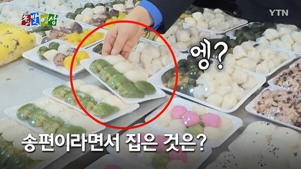 한성숙 국무총리가 지난 17일 서울시 관악구 신원시장을 방문해 떡을 구매하고 있는 모습. @ YTN 돌발영상 화면캡처.