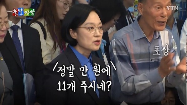 한성숙 국무총리가 지난 17일 서울시 관악구 신원시장을 방문해 떡을 구매하고 있는 모습. @ YTN 돌발영상 화면캡처.