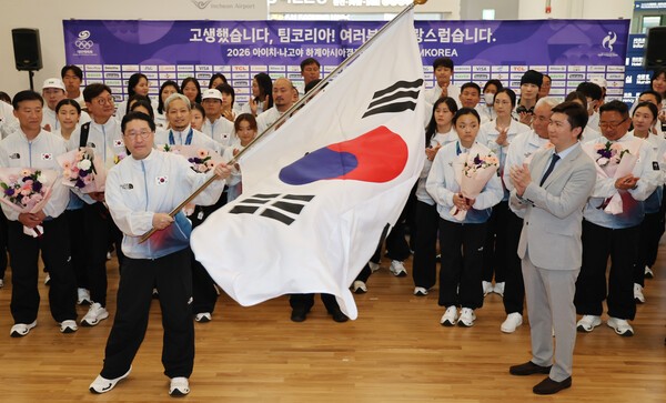 이상현 선수단장이 지난 5일 인천국제공항 제2여객터미널에서 열린 2026 아이치·나고야 아시아경기대회 대한민국 선수단 해단식에서 태극기를 흔들고 있다. @ 연합뉴스