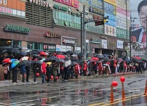 비 내리는 선거운동 첫날, 우산 든 지지자와 청중들